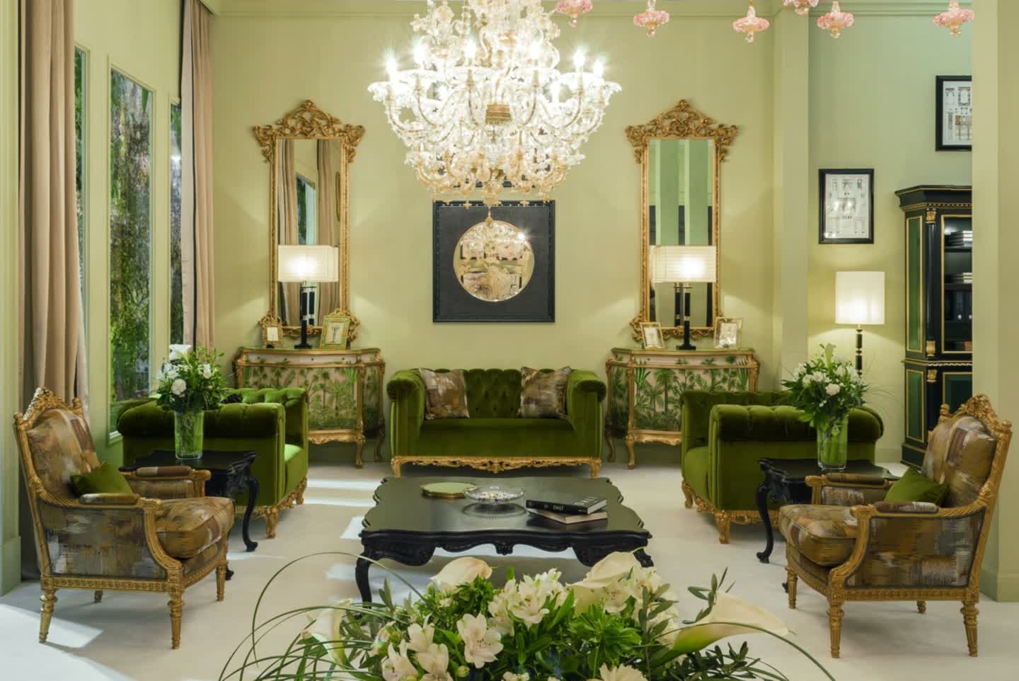 Salone di un palazzo classico italiano arredato da Fratelli Radice, con specchiera e consolle dorate, pareti in damasco bordeaux e parquet a spina